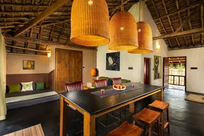 a room with a table and chairs and some lights at Kudisai Marayoor - Munnar in Munnar