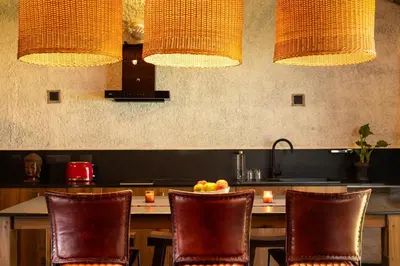 a kitchen with a table with chairs and a sink at Kudisai Marayoor - Munnar in Munnar