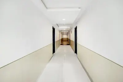 an empty corridor in a building with white walls and ceilings at Super Townhouse City Center Near Mysore Palace Formerly Aavass Inn in Mysore