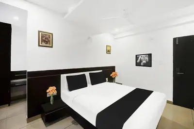 a bedroom with a black and white bed and flowers at Super Townhouse City Center Near Mysore Palace Formerly Aavass Inn in Mysore