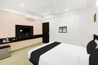 a hotel room with a bed and a tv at Super Townhouse City Center Near Mysore Palace Formerly Aavass Inn in Mysore