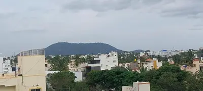 a city with buildings and a mountain in the background at Sky Inn in Mysore