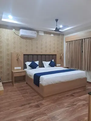 a bedroom with a large bed with blue pillows at Sky Inn in Mysore