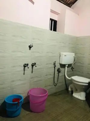 a bathroom with a toilet and buckets in it at Neermathalam, a traditional kerala tharavadu in Palakkad