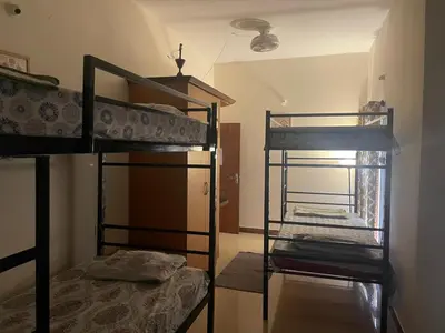 two bunk beds in a room with a window at Neha's Homestay in Mysore