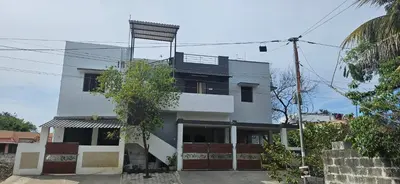 a white building with a balcony on top of it at SHIs Spandha Apartments Near Coimbatore Airport in Coimbatore