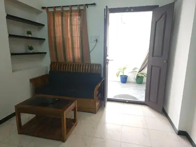 a living room with a couch and a sliding door at SHIs Spandha Apartments Near Coimbatore Airport in Coimbatore