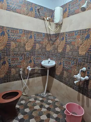 a bathroom with a toilet and a sink in a room at SHIs Spandha Apartments Near Coimbatore Airport in Coimbatore