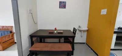 a small room with a small table and a stool at SHIs Spandha Apartments Near Coimbatore Airport in Coimbatore