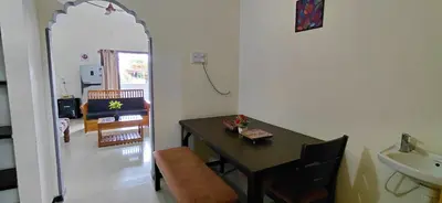 a dining room with a table and a sink in a room at SHIs Spandha Apartments Near Coimbatore Airport in Coimbatore