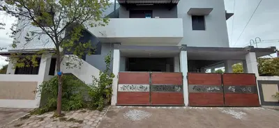 a house with a red gate in front of it at SHIs Spandha Apartments Near Coimbatore Airport in Coimbatore