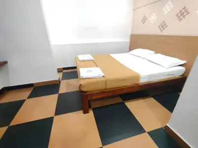 a bed in a room with a checkered floor at Nandan Residency in Mysore