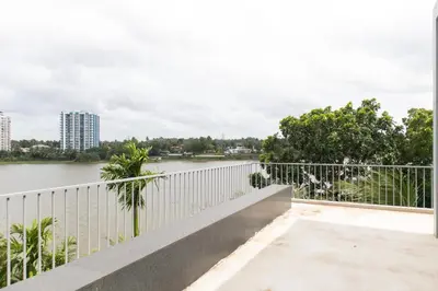 a bridge over a river with buildings in the background at Rosy Villa - Riverside Stay with Pool & View in Alwaye