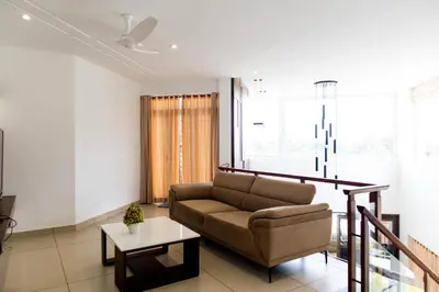 a living room with a couch and a table at Rosy Villa - Riverside Stay with Pool & View in Alwaye