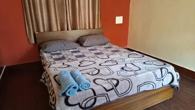 a bedroom with a bed with two towels on it at Golden Nest Home Stay in Mysore