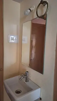a bathroom with a sink and a mirror at Golden Nest Home Stay in Mysore