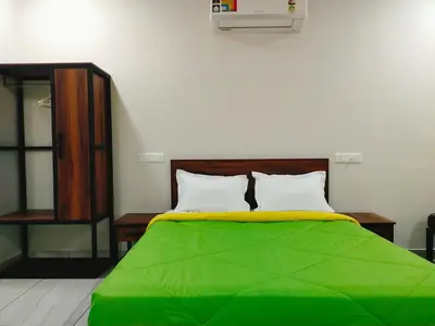 a bedroom with a green bed with two pillows at Bamboo Suite at Merlys Fruit Garden in Kotamangalam