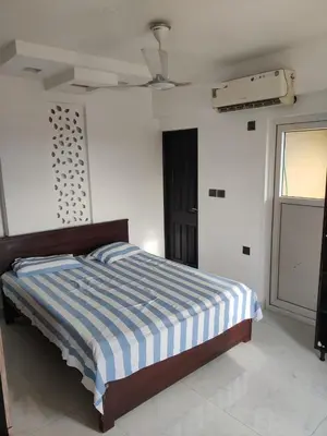 a bed in a white room with a ceiling at Urban Oasis in Trichūr
