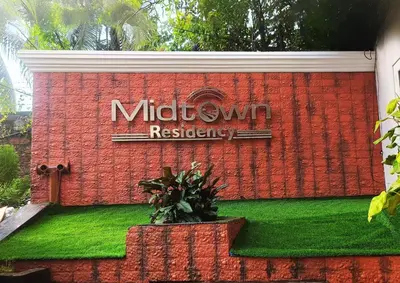 a sign on the side of a brick building at Midtown Residency in Kozhikode