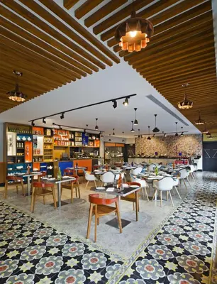 a restaurant with tables and chairs in a room at Zone By The Park Coimbatore in Coimbatore