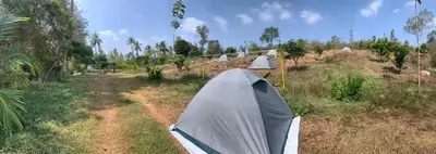a tent in the middle of a field at Wilderness Jungle Camp in Malavalli