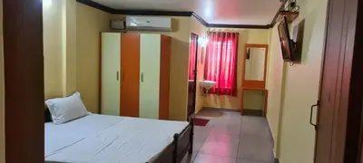 a small room with a bed and a bathroom at Prestige Tourist Home in Nedumbassery