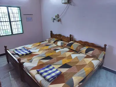 a large bed with pillows on it in a room at Honeycomb Homestay Ground Floor in Palani