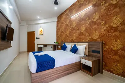 a bedroom with a bed with blue and white sheets at Amala Arcade AC Rooms in Trichūr
