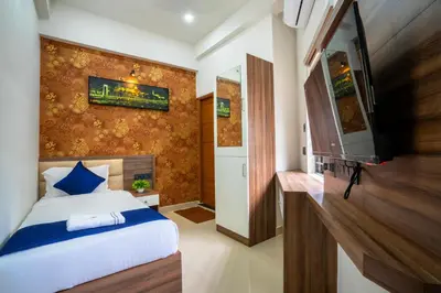 a bedroom with a bed and a flat screen tv at Amala Arcade AC Rooms in Trichūr