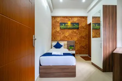 a small bedroom with a bed and a wall at Amala Arcade AC Rooms in Trichūr