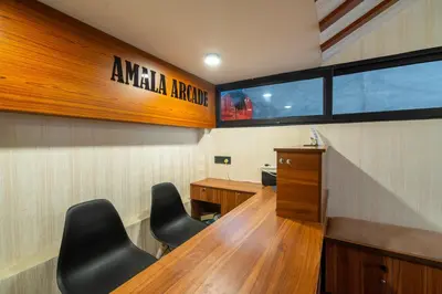 a conference room with a desk and chairs in it at Amala Arcade AC Rooms in Trichūr