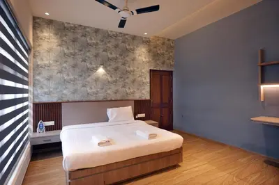 a bedroom with a white bed and a wall at Sannidhi Homes Palakkad in Palakkad