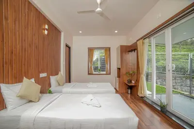a bedroom with two beds and a large window at Abhinav Nest by Xplore Indo in Kodanād
