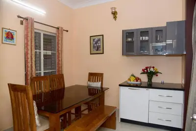 a dining room with a table and chairs at Ac 3 Bedroom House Mysore in Mysore