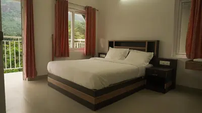 a bedroom with a bed and a large window at Rains Valley Resort By Teal Luxury Stays in Viripara