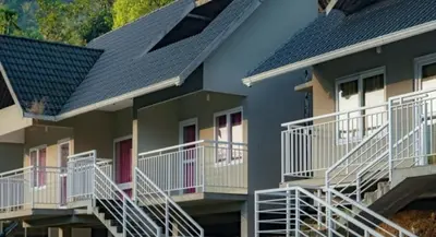 a row of houses with balconies and roofs at Rains Valley Resort By Teal Luxury Stays in Viripara