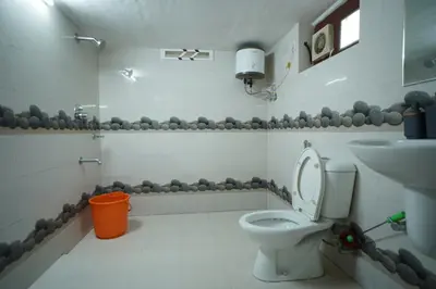 a bathroom with a toilet and a sink at Wayanad Palm Grove Retreat 1st Floor in Wayanad