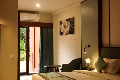 a hotel room with a bed and a table and a window at Sahya Regency in Ottappālam