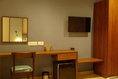 a room with a desk with a television and a chair at Sahya Regency in Ottappālam