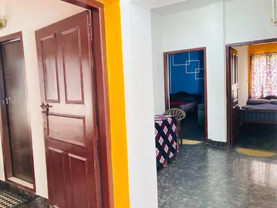 a hallway with a door and a room with a couch at Swarna Tourist home Munnar in Munnar