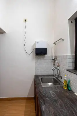 a kitchen with a sink and a tv on the wall at Nest Villa - A Homely Heaven Near the Skies in Nedumbassery