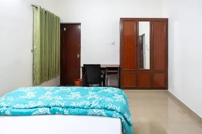 a bedroom with a bed and a desk and a table at Nest Villa - A Homely Heaven Near the Skies in Nedumbassery