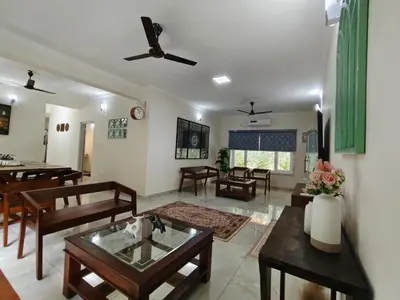 a living room with a table and chairs at 7 Elysee Homestay - Lapis - Premium 3BHK Family Flat in Trichūr