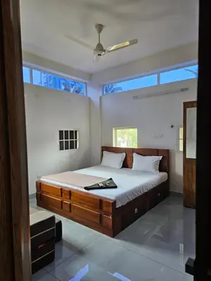a bedroom with a large bed with a large window at Yogis Stay in Kozhikode