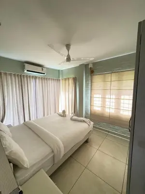 a bedroom with a bed and a window with curtains at River Wild holiday home in Athirappilly