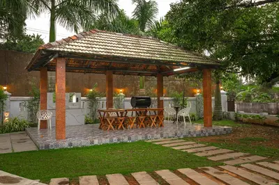 a wooden gazebo with a table and a grill at Tamarind Heritage Holiday Home in Angamali