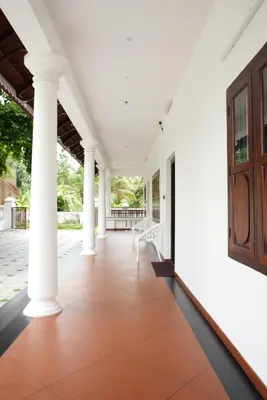 an empty porch of a house with white columns at Tamarind Heritage Holiday Home in Angamali