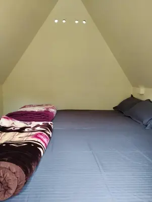 a large bed in a room with a roof at Hazy Mount Vattavada in Kottakamboor