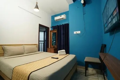 a bedroom with a bed and a blue wall at Twinn Waves By Atmos in Kozhikode