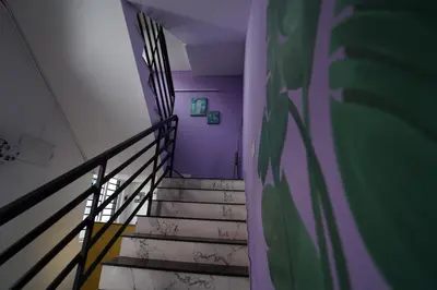 a stairway with a purple wall and purple stairs at Twinn Waves By Atmos in Kozhikode